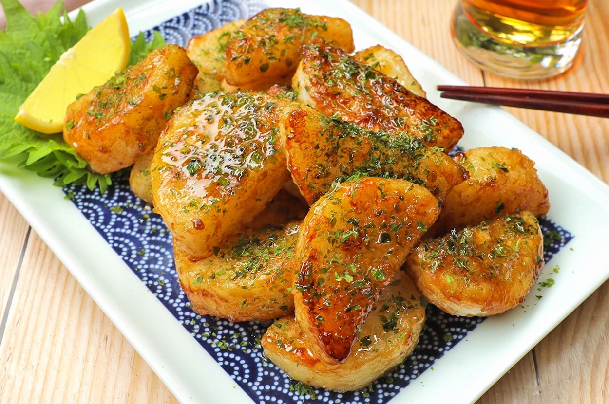 揚げたポテトの皿。青じそ、海苔がトッピングされ、レモンと飲み物が添えられている。