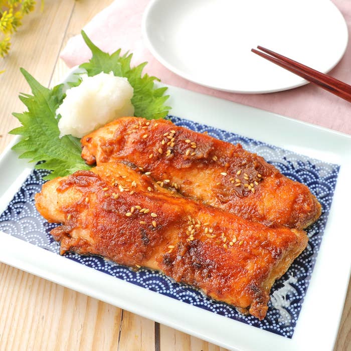 お皿に盛り付けられた鮭のフィレ、付け合わせに大根おろしとシソの葉が添えられています。