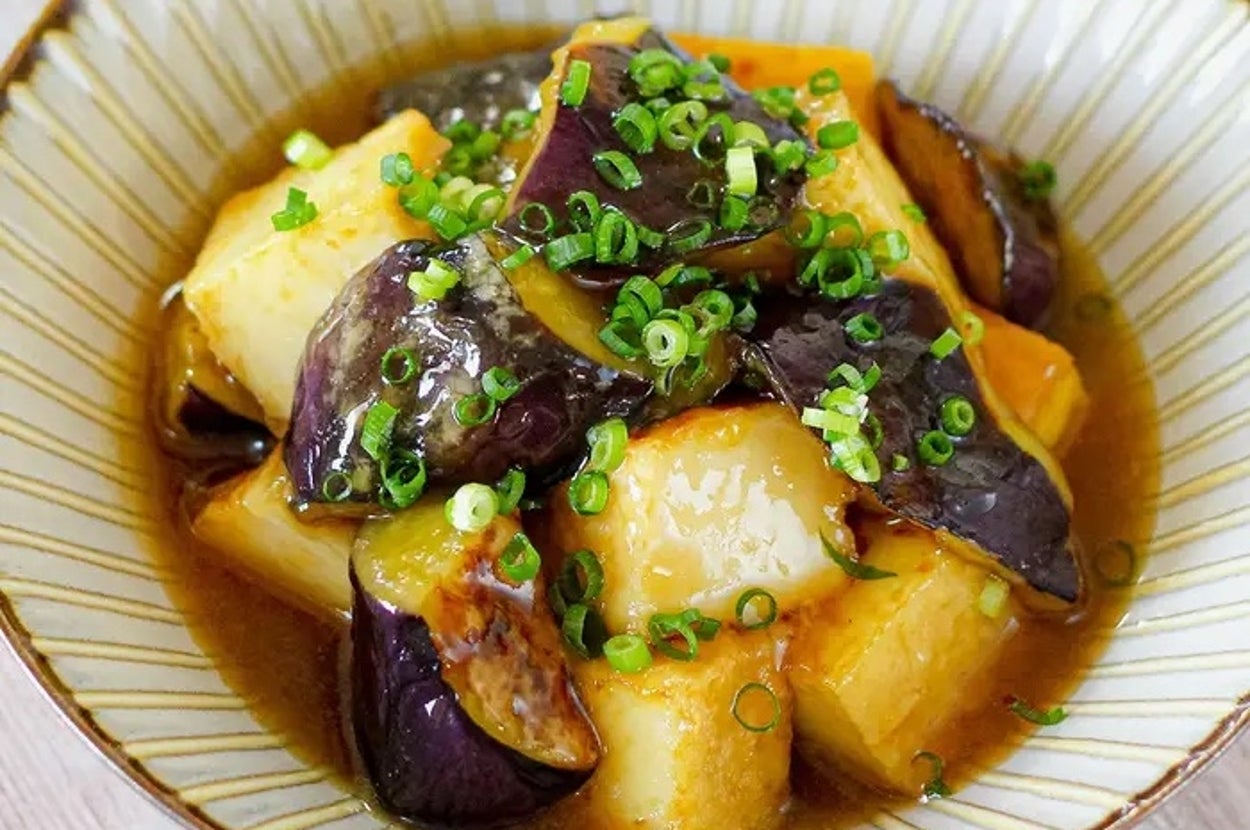 茄子と豆腐が入った和風の煮物が器に盛られている。刻んだネギが上に乗っている。