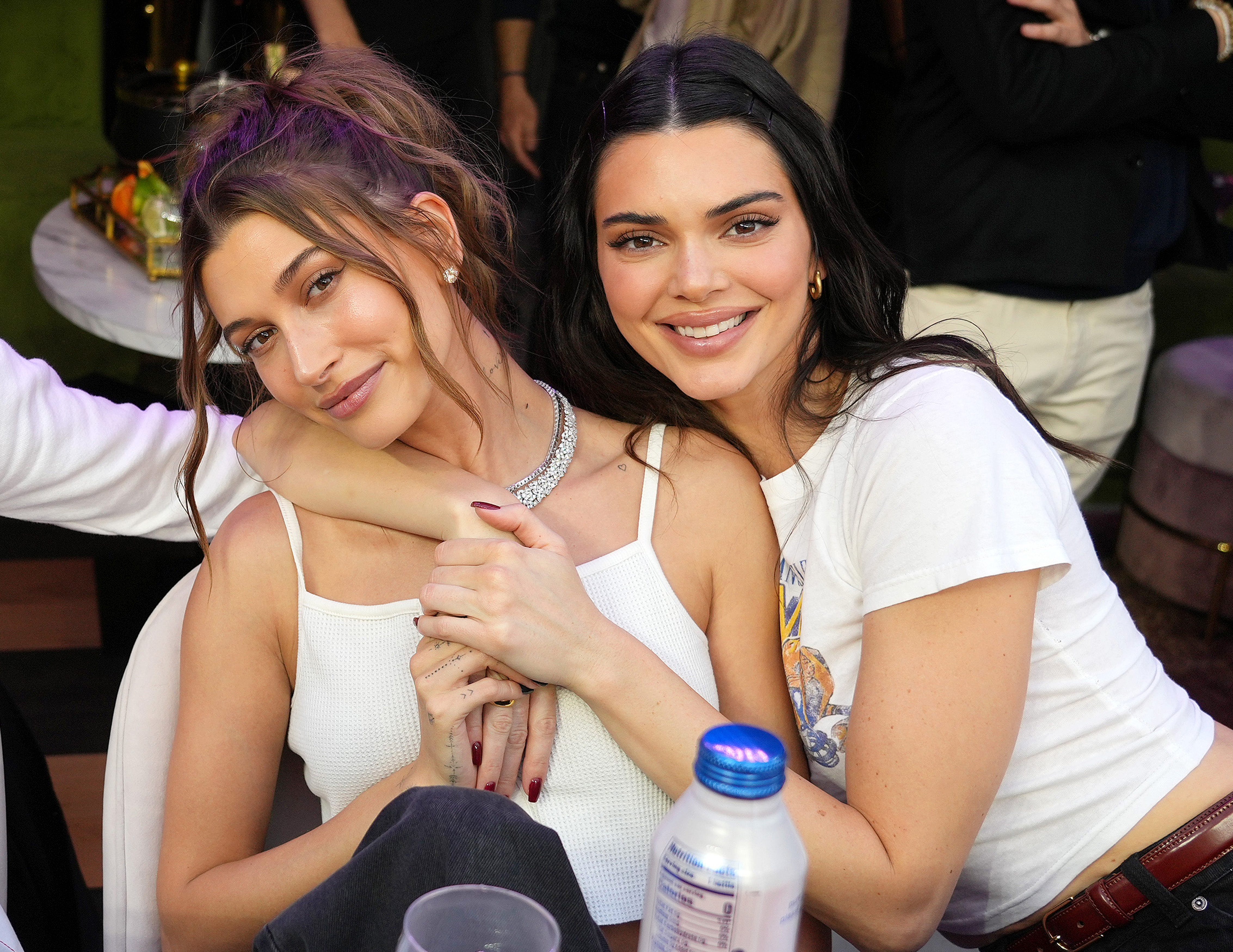 Hailey Bieber and Kendall Jenner smiling and embracing at a casual event