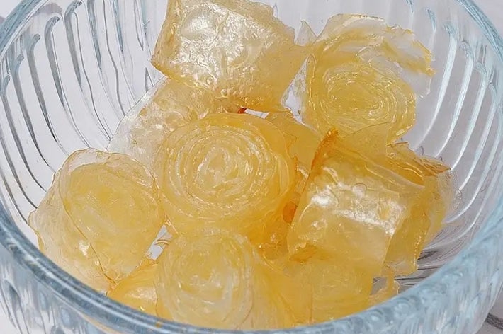 ガラスのボウルに入った透き通った薄いロール状のキャンディ。