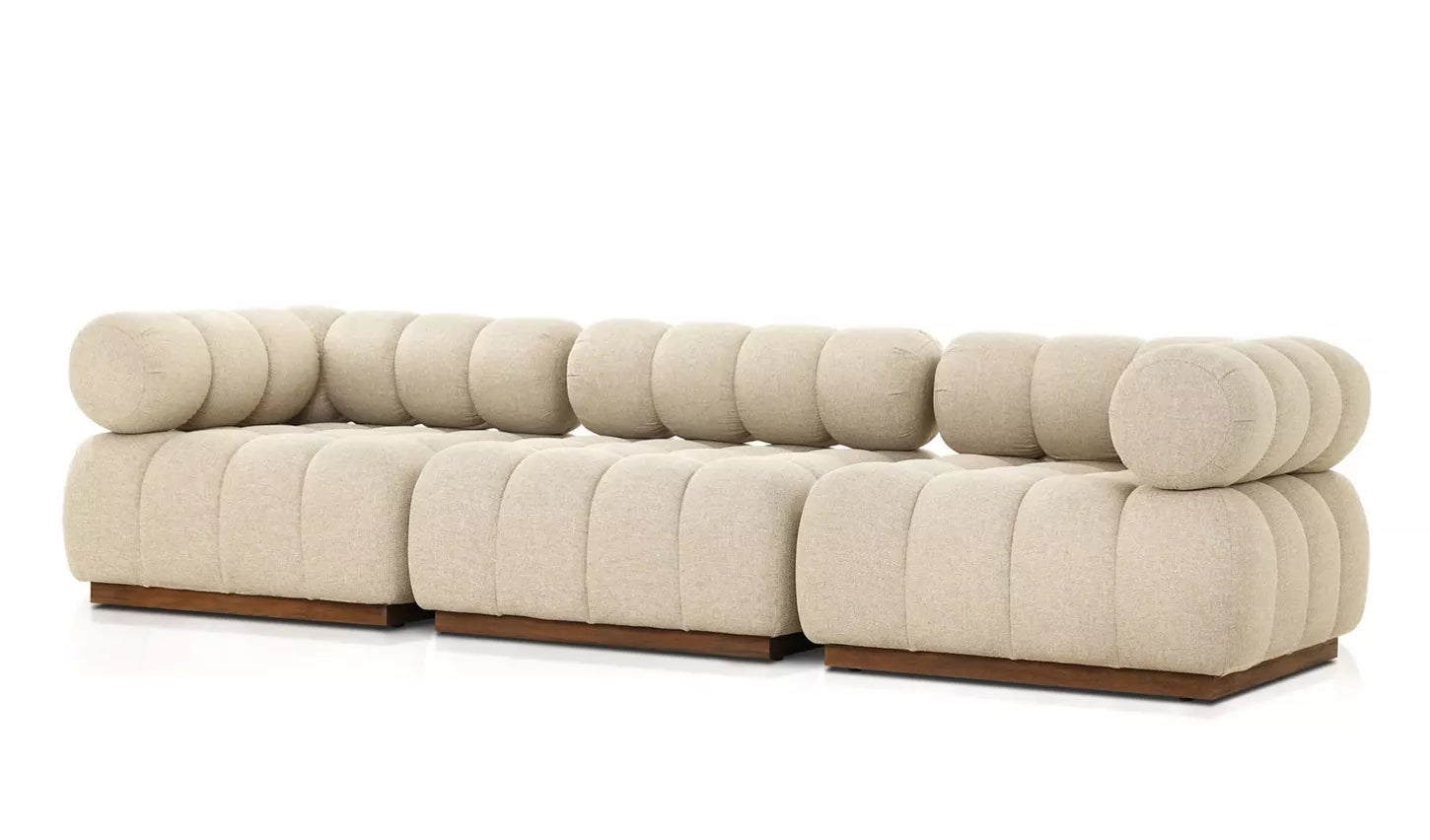 A modular beige sofa with rounded cushions and wooden base, ideal for modern living spaces