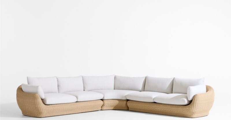 Modern curved sectional sofa with woven base and white cushions