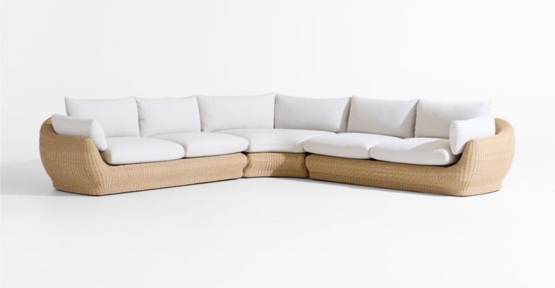 Modern curved sectional sofa with woven base and white cushions