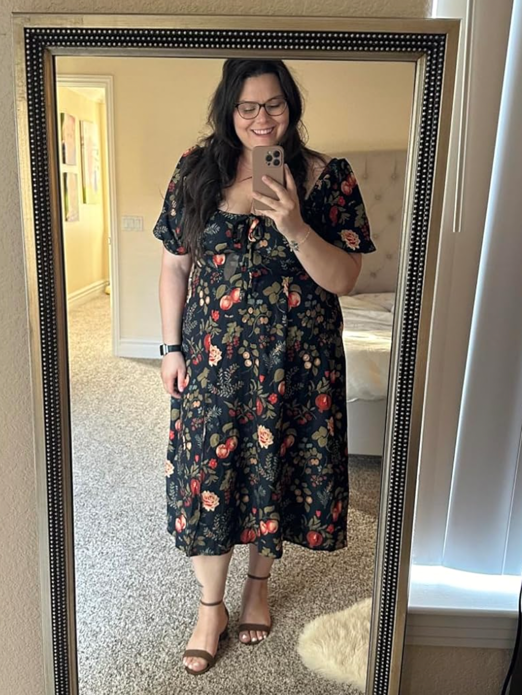 Person taking a reflector  selfie, wearing a floral-patterned formal  and sandals, smiling
