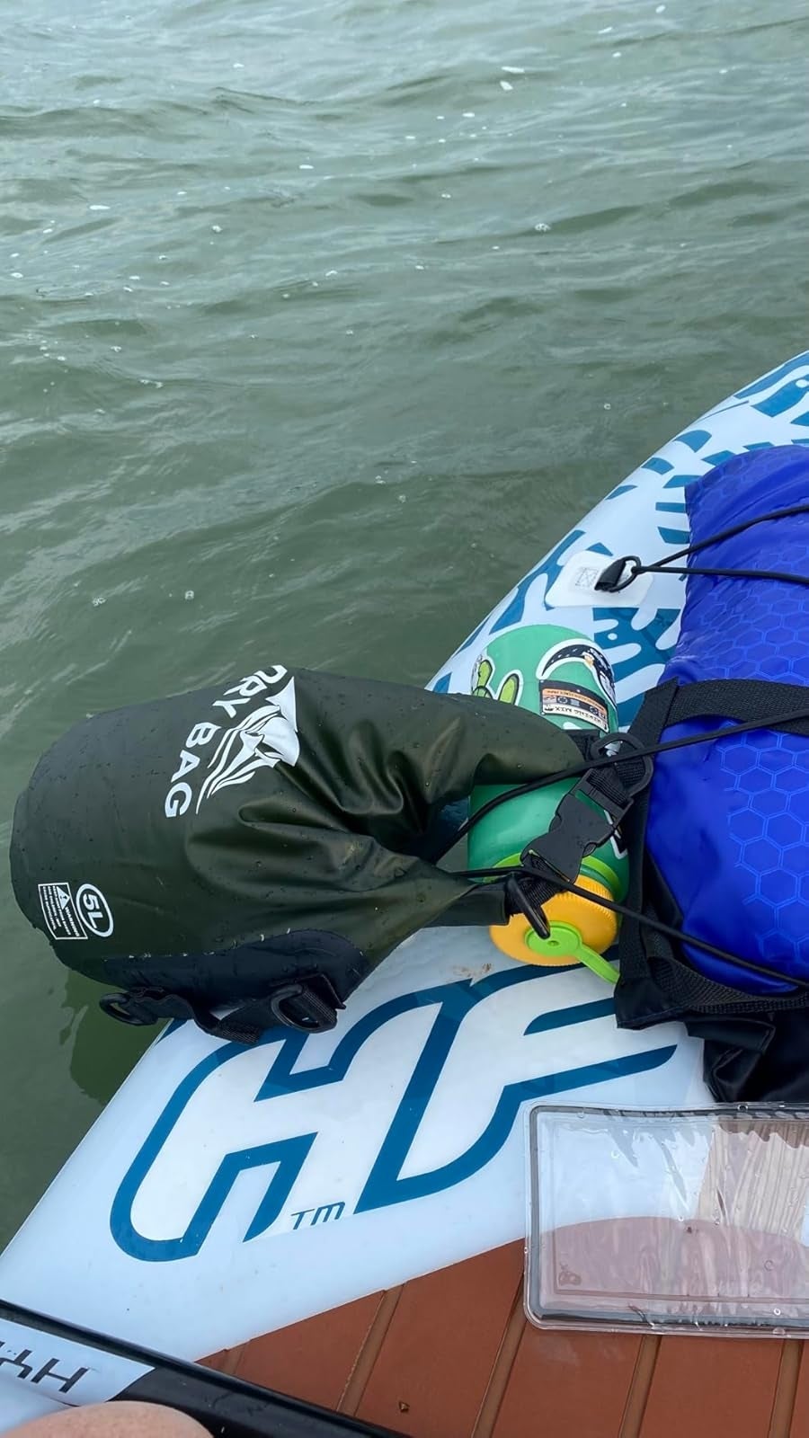 A paddleboard with a reviewer's adust  container  and colorful formation  towels connected  apical  floats connected  the water