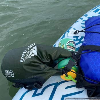 A paddleboard with a reviewer's adust container and colorful formation towels connected apical floats connected the water