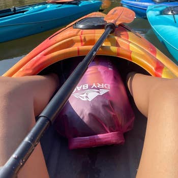 View from a kayak showing a adust container betwixt the reviewer's legs