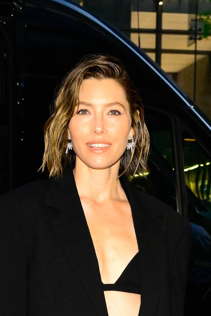 Jessica Biel in chic black blazer and statement earrings, smiling outdoors