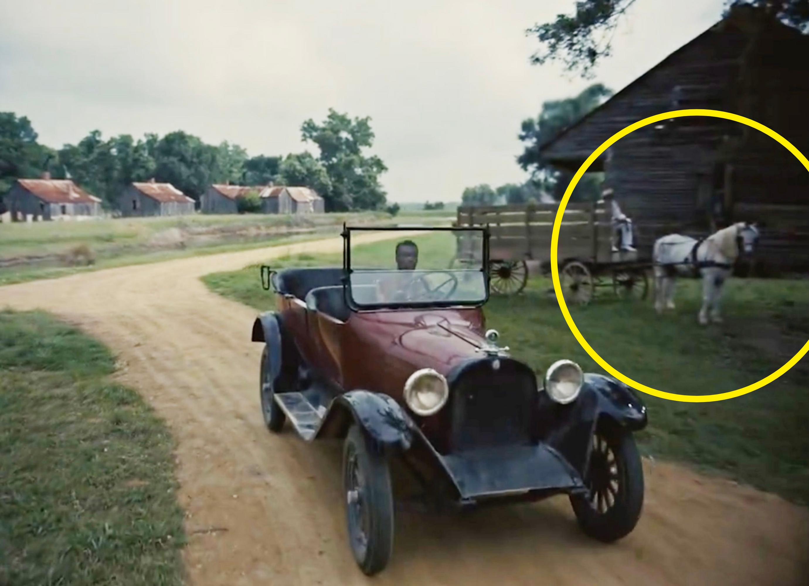 Sammie driving a vintage car with a circle around a white horse near the car