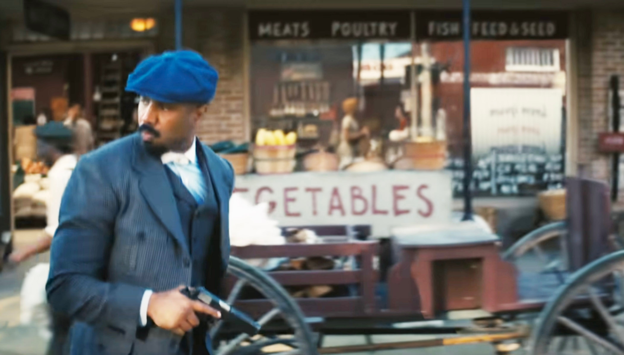 Smoke walking through town holding a gun. He passes by a grocery store