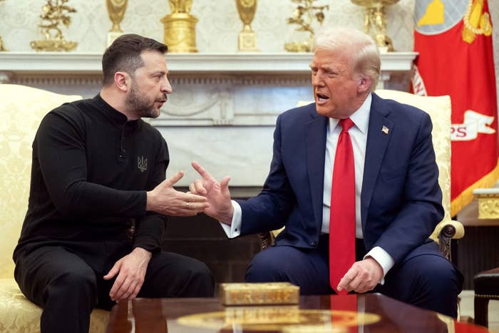 Two individuals are sitting and engaged successful a handshake conversation. One wears a suit, and the different is successful a casual outfit. They look to beryllium successful an ornate room