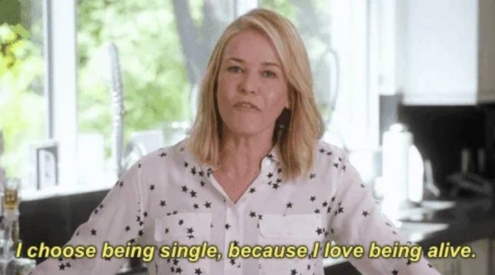 Woman in a star-patterned blouse says, "I choose being single, because I love being alive," in a casual kitchen setting