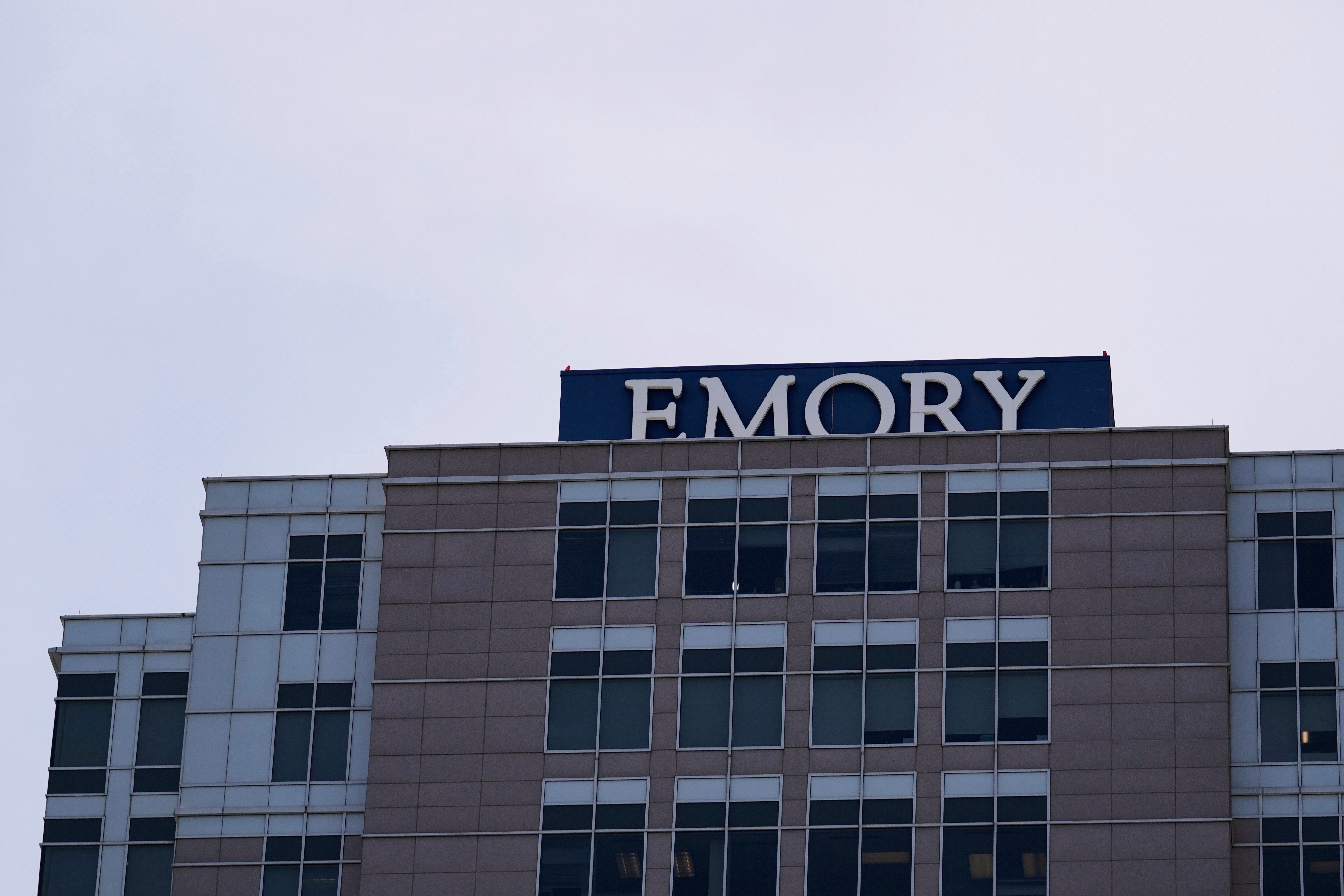 A modern hospital building with the sign "EMORY" on the rooftop