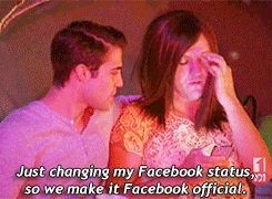 Two people sitting together. One is changing their Facebook status on a phone. Caption reads, "Just changing my Facebook status, so we make it Facebook official."