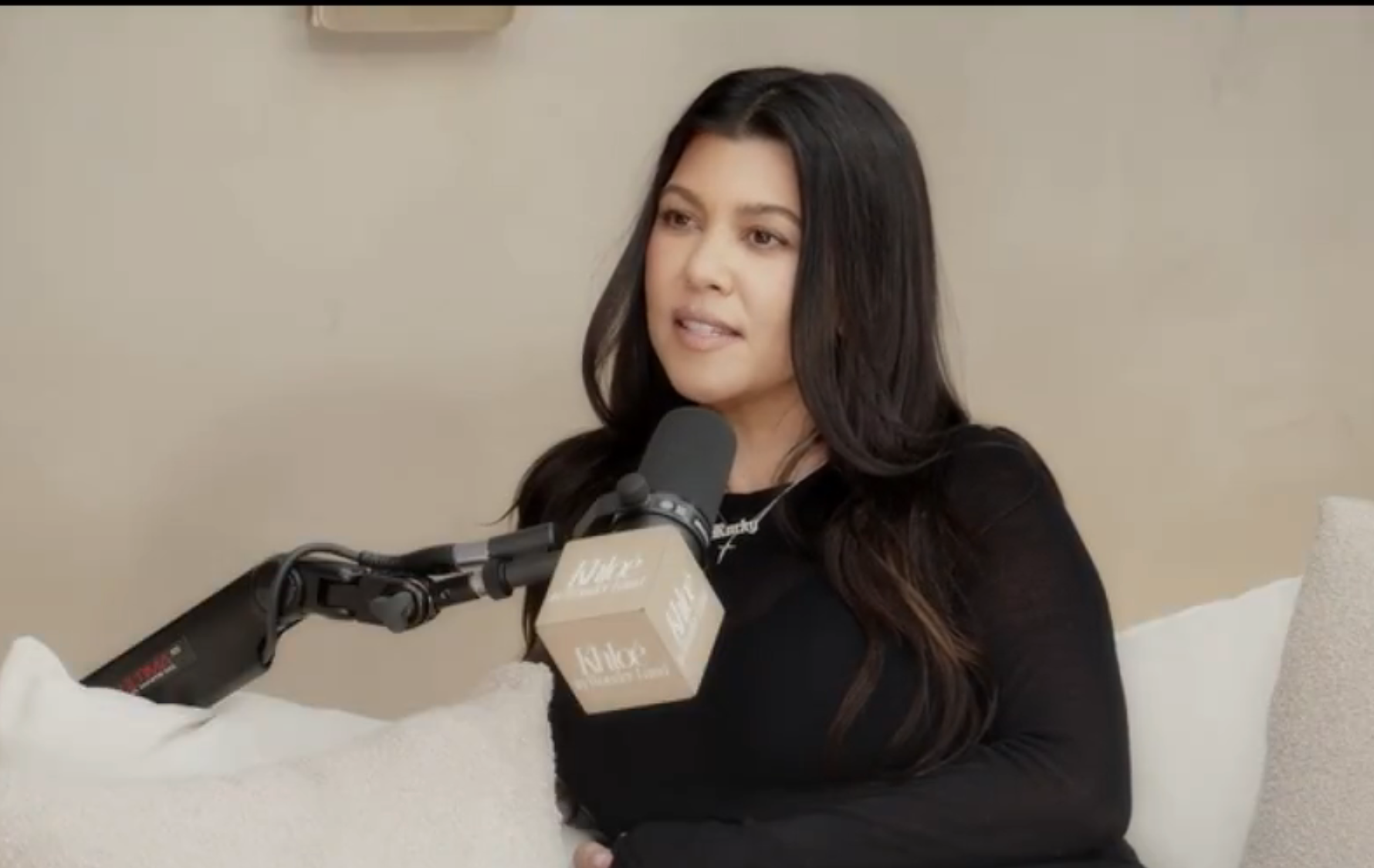 Kourtney Kardashian speaking into a microphone during a podcast