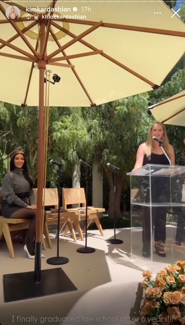 Kim Kardashian sits wearing a graduation cap during her law school graduation while her mentor gives a speech