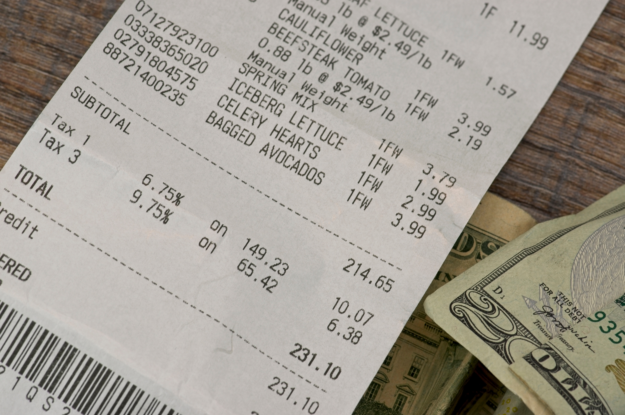Grocery receipt showing purchases of cauliflower, beefsteak tomatoes, lettuce, celery hearts, and avocados. Total: $231.10. Cash partly visible