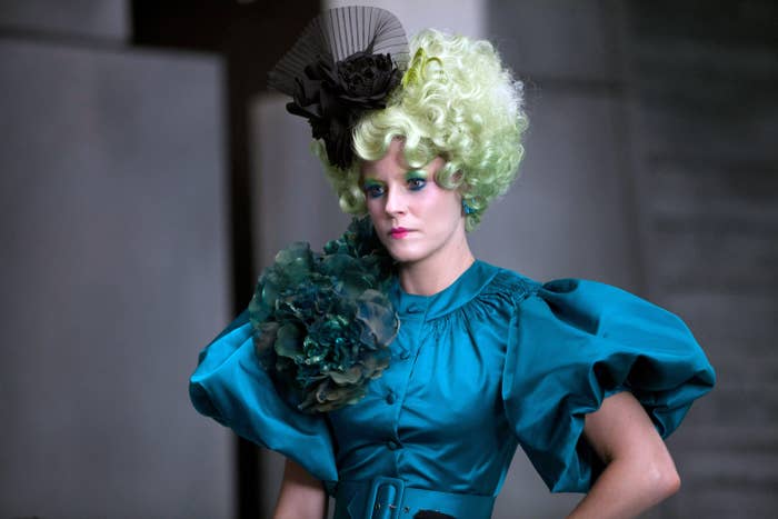 Elizabeth in extravagant costume with voluminous, ruffled dress and an elaborate headpiece