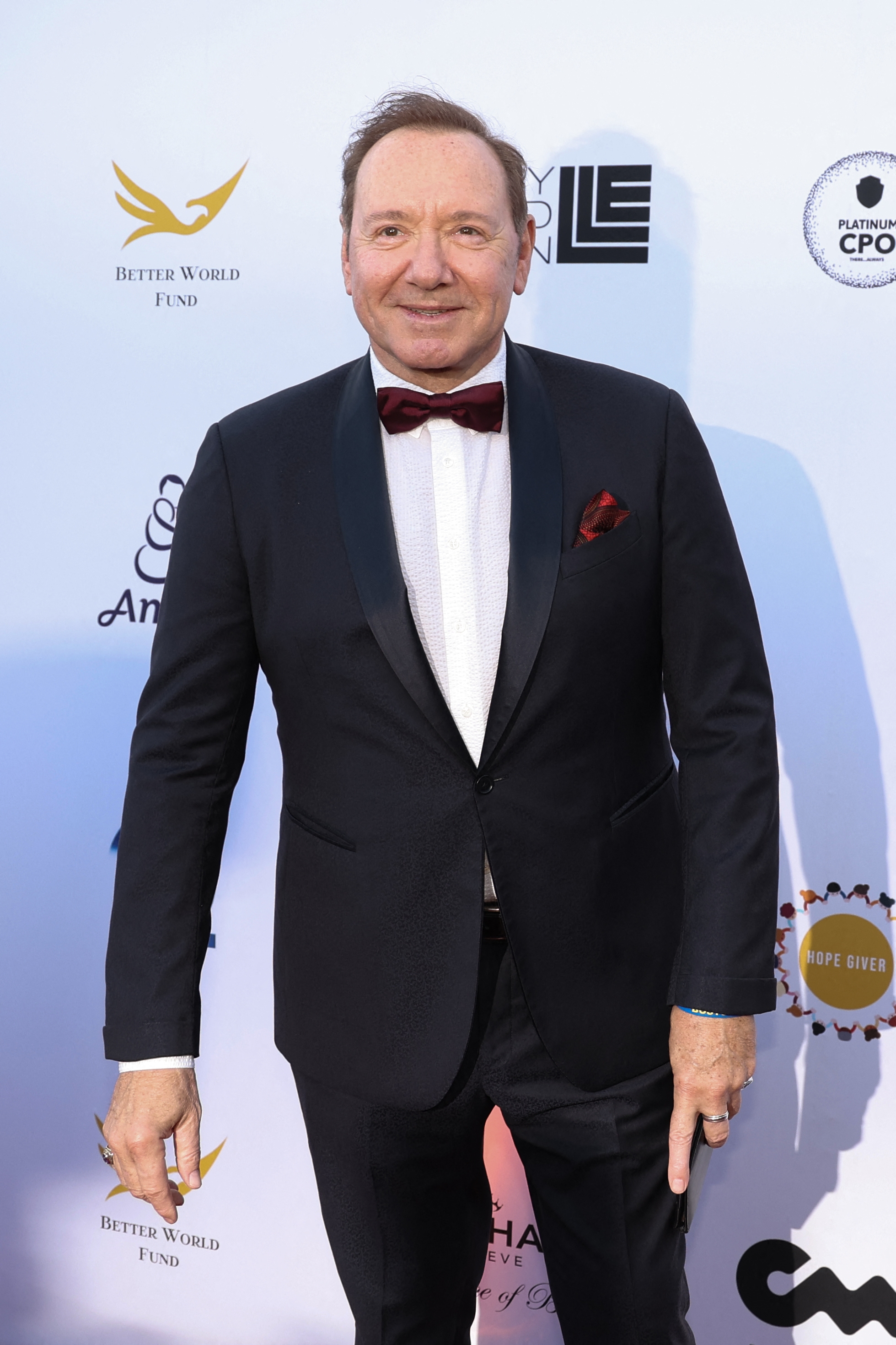 Man in a formal tuxedo with a bow tie on a red carpet attending an event