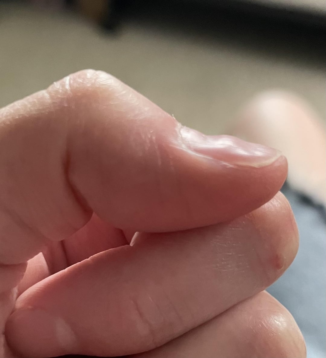 A close-up of a person's hand, fingers gently curled, with a blurred background