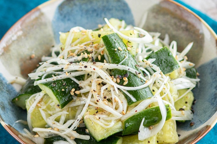 きゅうりと細切り玉ねぎのサラダがボウルに盛られている。ゴマとブラックペッパーがトッピングされている。