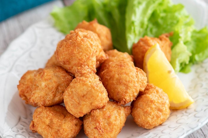 白い皿に盛られたフライドチキンとレタス、レモンのくし形切りが添えられた料理。