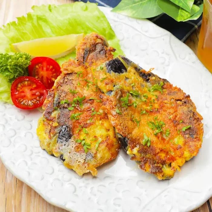 レタスとトマトを添えたカツレツが皿に盛られ、パセリで飾られている。