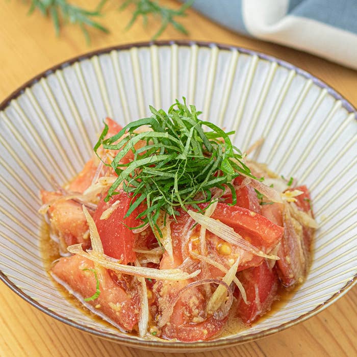 トマトと玉ねぎのスライスが入った爽やかな和風サラダ、青じそがトッピングされています。