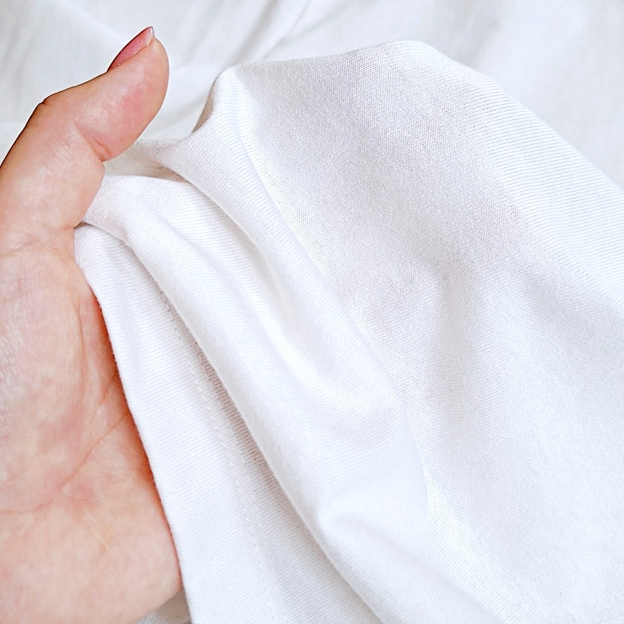 柔らかい布を持つ手。質感が伝わるように丁寧に広げている。