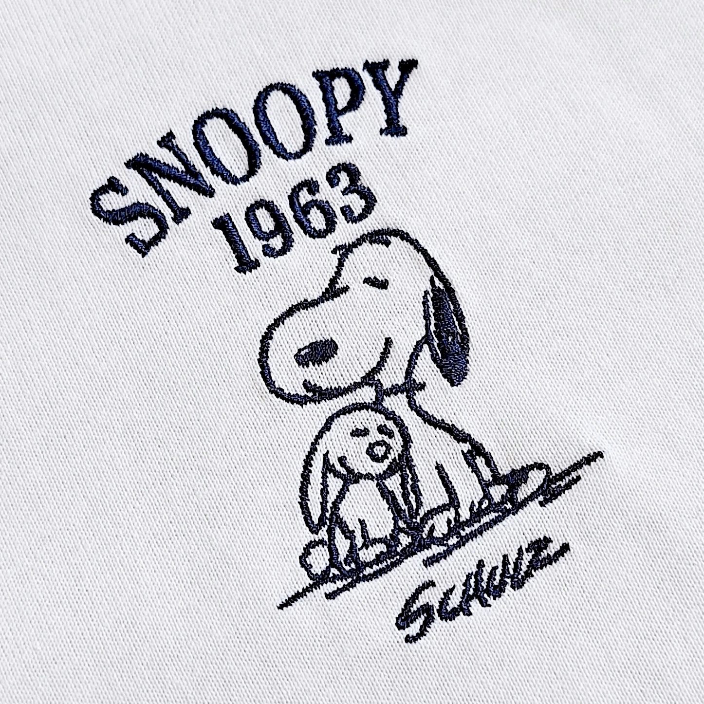 スヌーピーとウサギが寄り添うイラストに「SNOOPY 1963」「Schulz」の文字が刺繍されている。
