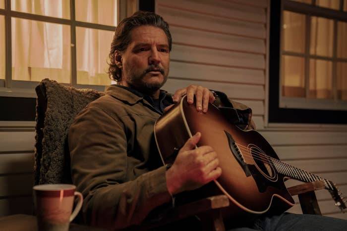 Joel sitting on the porch holding his guitar