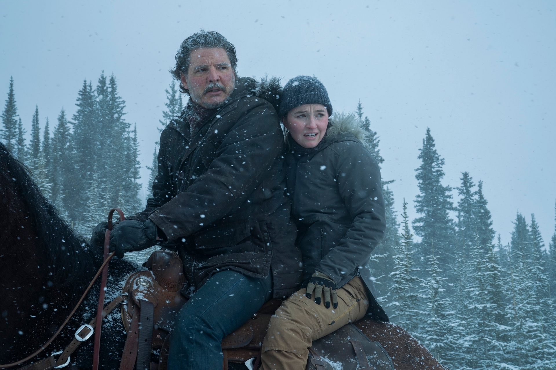 Abby riding behind Joel on a horse in the snow