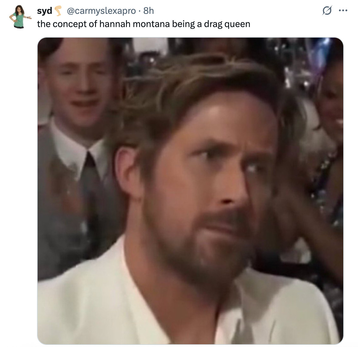 Person with facial hair looking skeptical while seated at an event, with people clapping in the background. Caption jokes about a concept