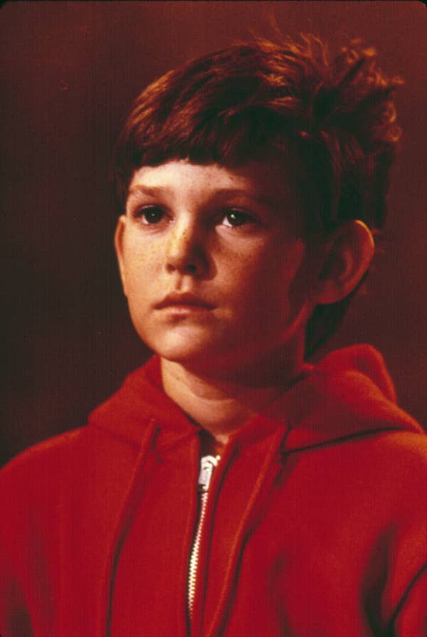 Young person in a casual zip-up hoodie, looking ahead with a neutral expression