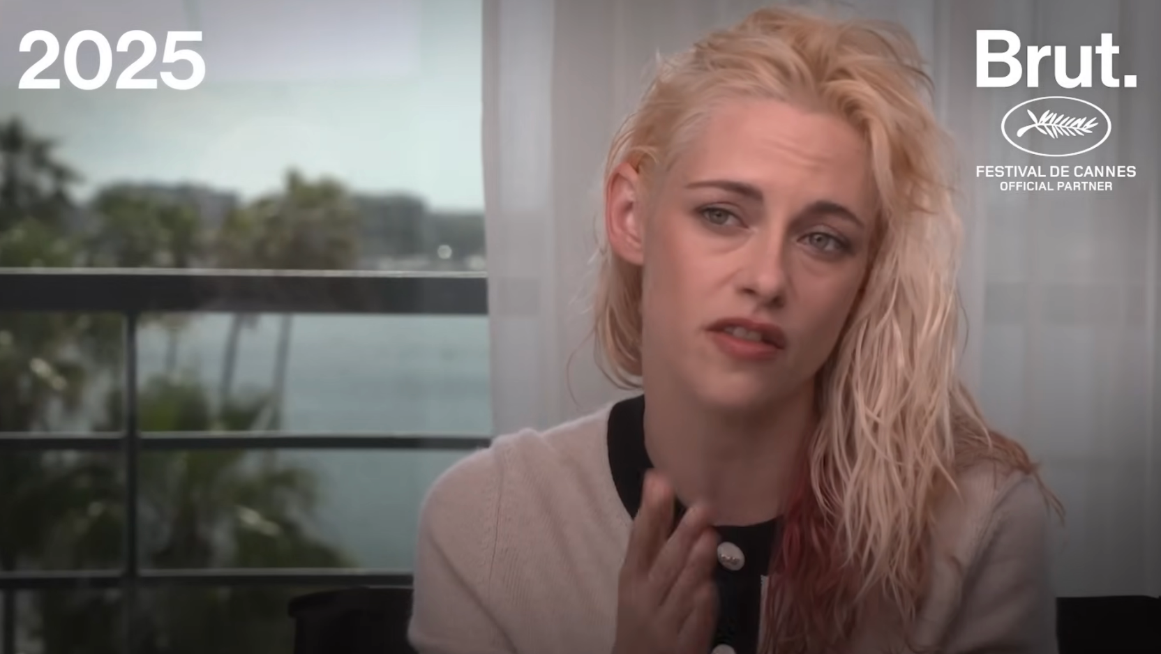 Person with layered hairstyle in casual cardigan giving an interview; text reads "2025" and "Brut. Festival de Cannes Official Partner"
