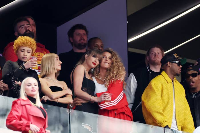 Group of people in a sports stadium box, dressed in casual and stylish attire, enjoying the event
