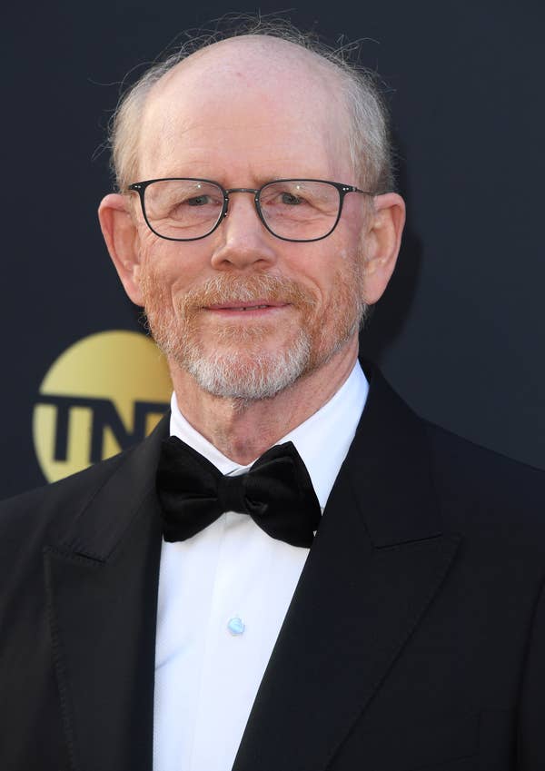 A man with glasses and a beard wearing a classic black tuxedo with a bow tie at a formal event