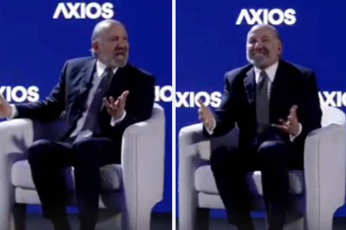 A person in a suit speaking animatedly while seated on stage at an Axios event