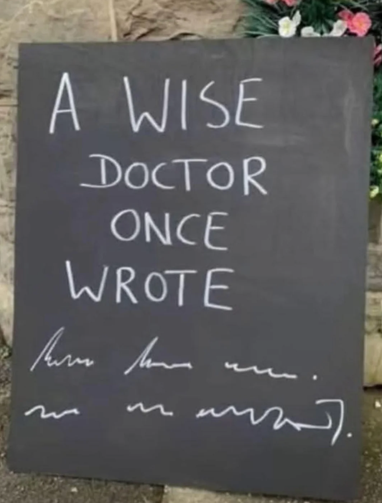 Chalkboard sign reads: "A wise doctor once wrote," followed by scribbles imitating illegible handwriting