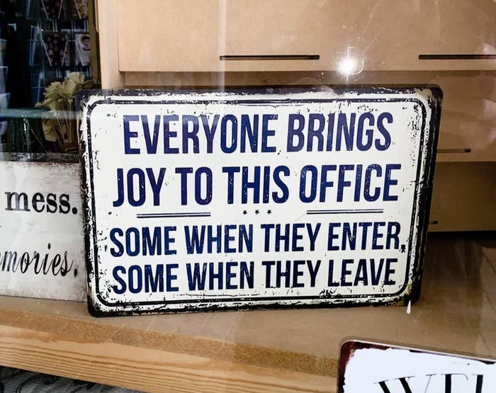 Humorous sign in an office reads: "Everyone brings joy to this office, some when they enter, some when they leave."