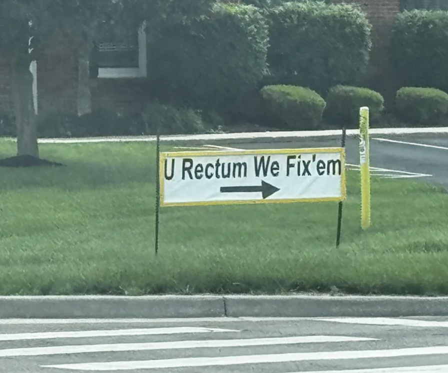 Sign on grass reads: "U Rectum We Fix'em" with an arrow pointing right