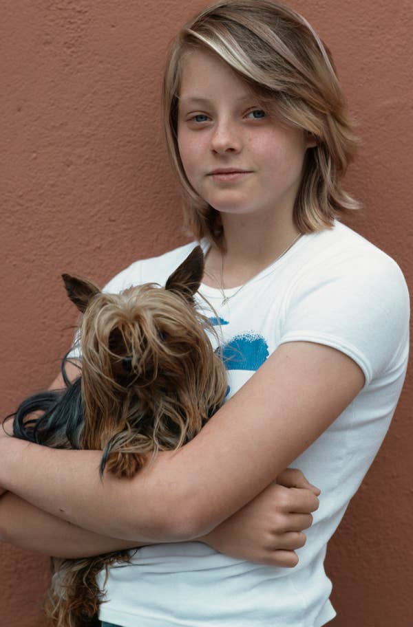 Person holding a small dog, wearing a casual t-shirt
