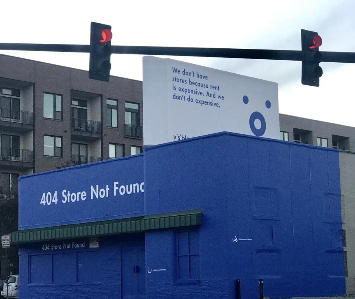 Building painted with "404 Store Not Found" and ad on top saying, "We don't have stores because rent is expensive. And we don't do expensive."
