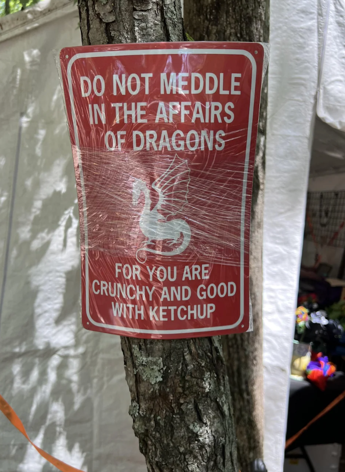 Sign on a tree reads: "Do not meddle in the affairs of dragons for you are crunchy and good with ketchup."