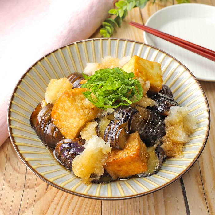 揚げ出し豆腐と茄子の和風料理が器に盛られている。上には青じそが載せられている。