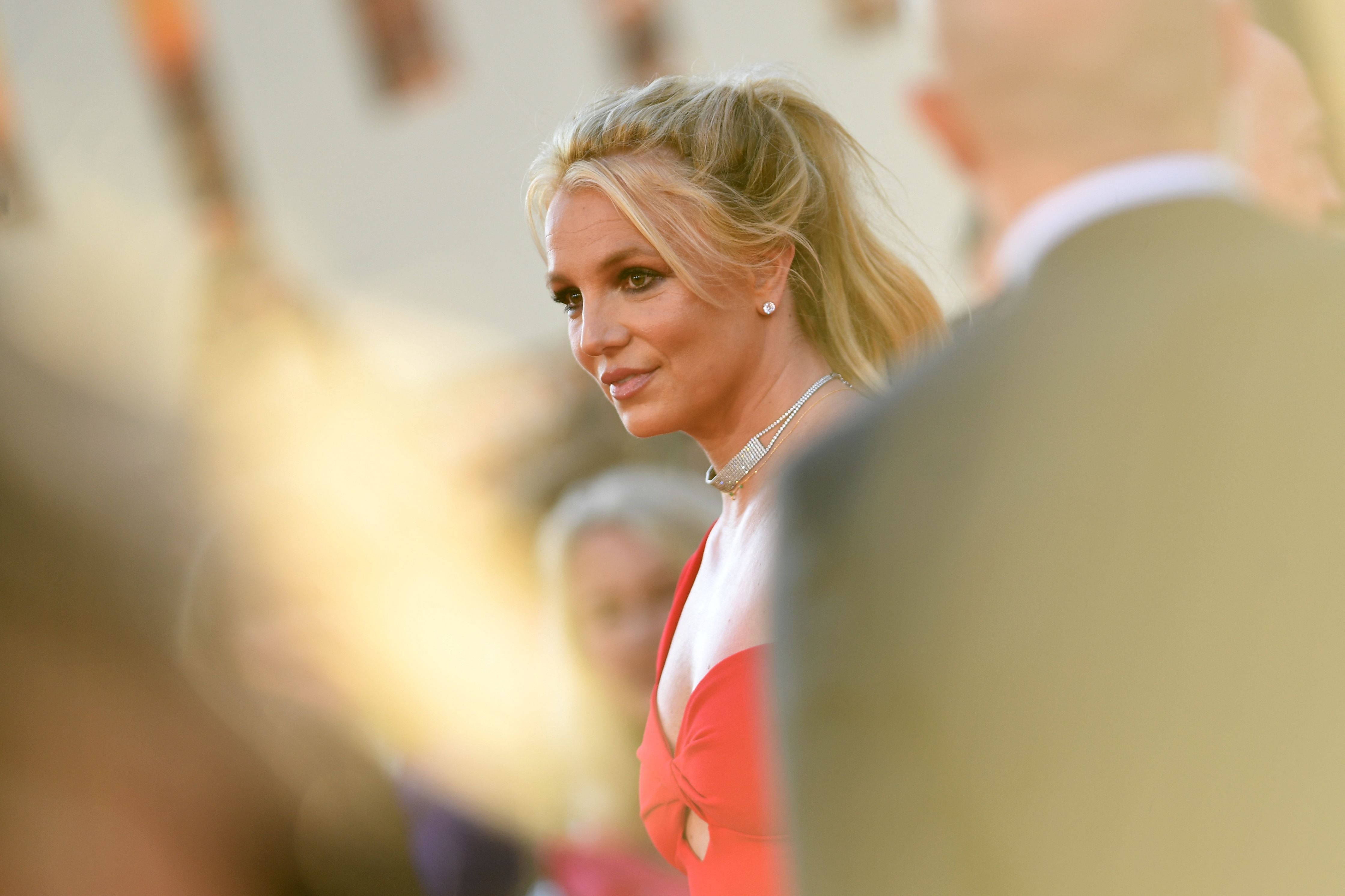 Britney Spears on the red carpet in an elegant dress, with styled hair, attending a celebrity event