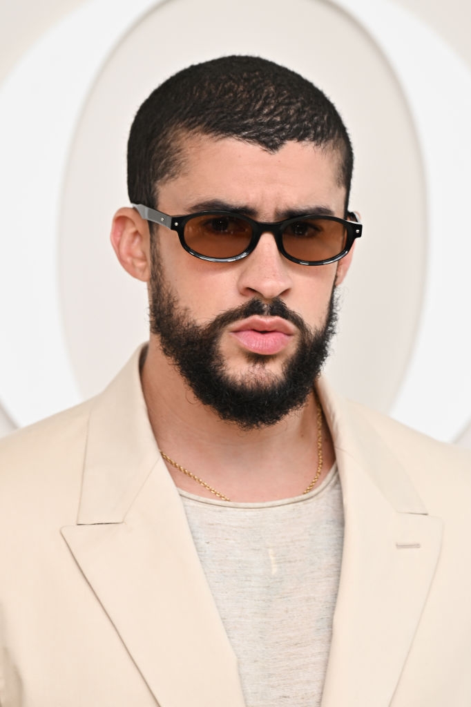 Man with sunglasses and a beard in a stylish beige blazer and light shirt at a celebrity event