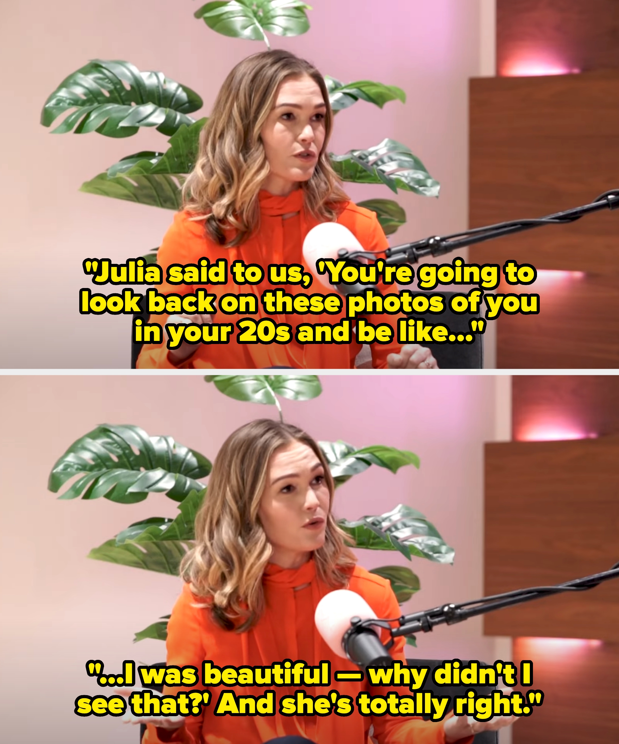 A woman in an orange blouse speaks into a microphone during a podcast recording, seated in front of a plant