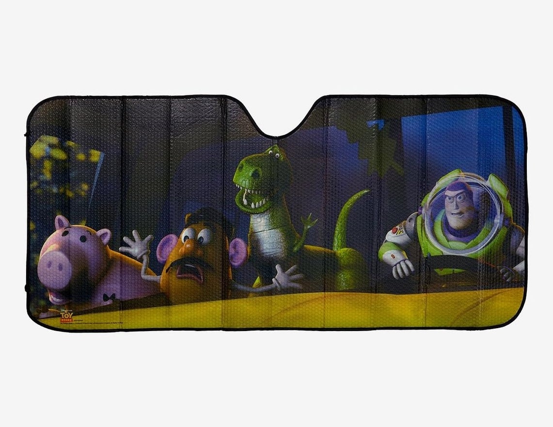 Car sunshade featuring characters from "Toy Story" with Hamm, Mr. Potato Head, Rex, and Buzz Lightyear looking surprised